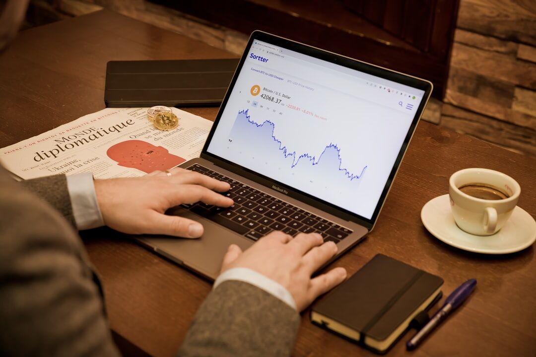 Close up of hands typing on laptop with marketing charts